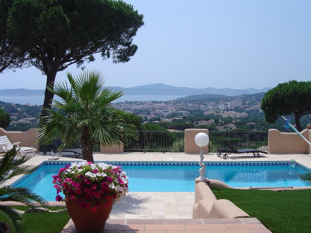 Cozy blue pool with iron and stucco railing on edge of cliff overlooking city and ocean. The pool is small with wrap-around patio. Cozy blue pool with iron and stucco railing on edge of cliff overlooking city and ocean. The pool is small with wrap-around patio.