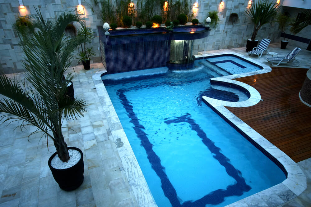 Small cozy courtyard pool with wood deck and stone patio. Small cozy courtyard pool with wood deck and stone patio.