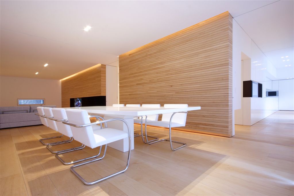 Wide angle of open dining area with large white table and metal frame seating, living room in background. Wide angle of open dining area with large white table and metal frame seating, living room in background.