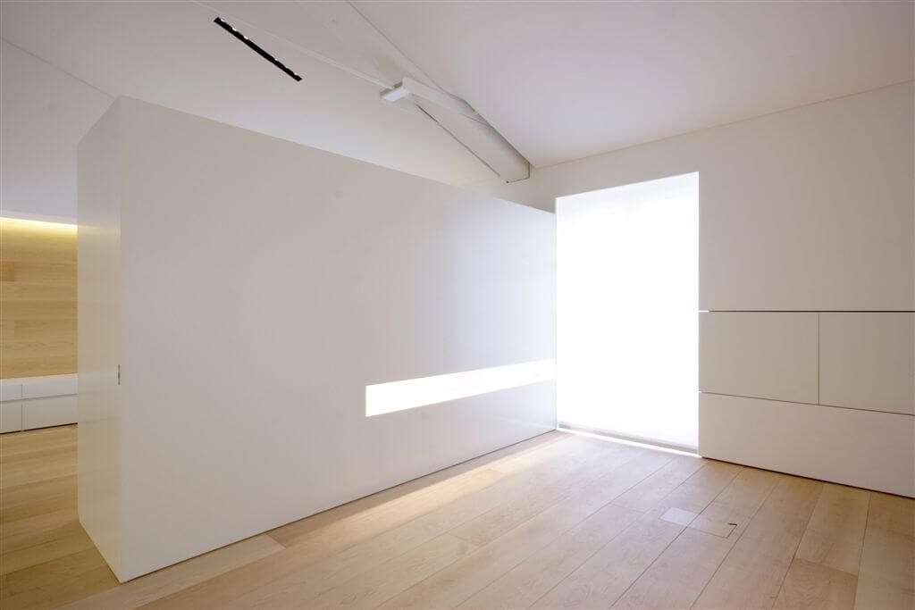 Far end of living room, with dividing wall featuring built-in lighting and hidden storage. Far end of living room, with dividing wall featuring built-in lighting and hidden storage.