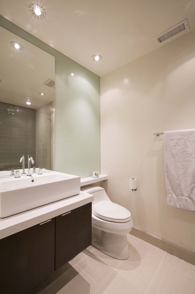 Bathroom awash in light tones, recessed lighting, dark wood cabinets and large basin sink. Bathroom awash in light tones, recessed lighting, dark wood cabinets and large basin sink.