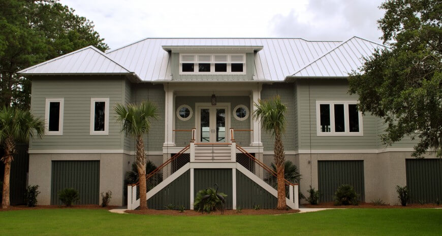 Front view of house with upper level split-stair entrance way and twin port windows. Front view of house with upper level split-stair entrance way and twin port windows.