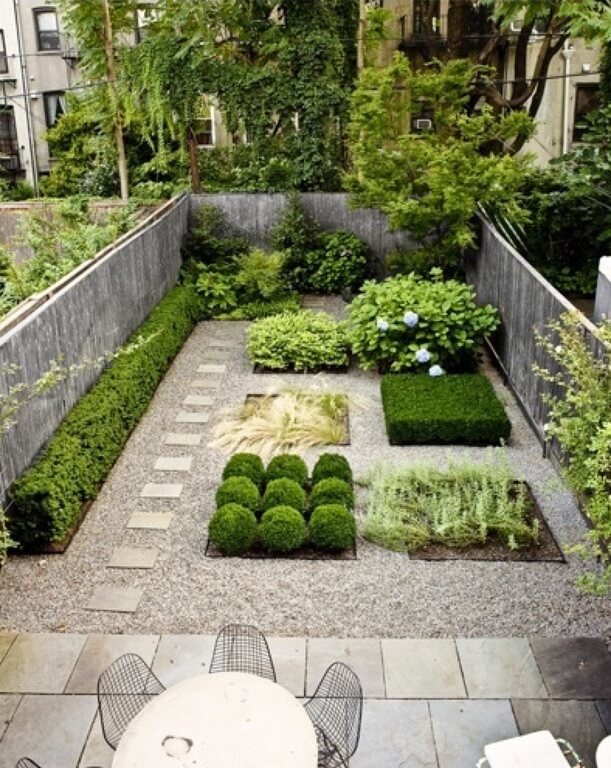  small shrubs are added in small, square sections of this zen garden