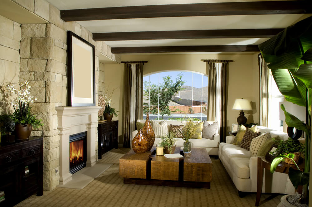 Contemporary living room design with stone fireplace, white mantle, carpeting, white sofas and beige carpeting.