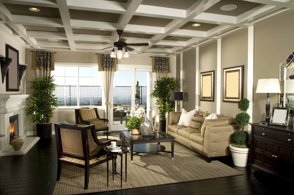 Living room design with glass doors to large patio.  Dark wood floor with brown rug sets the setting for the contemporary furniture, white and beige color scheme all set around a white fireplace.