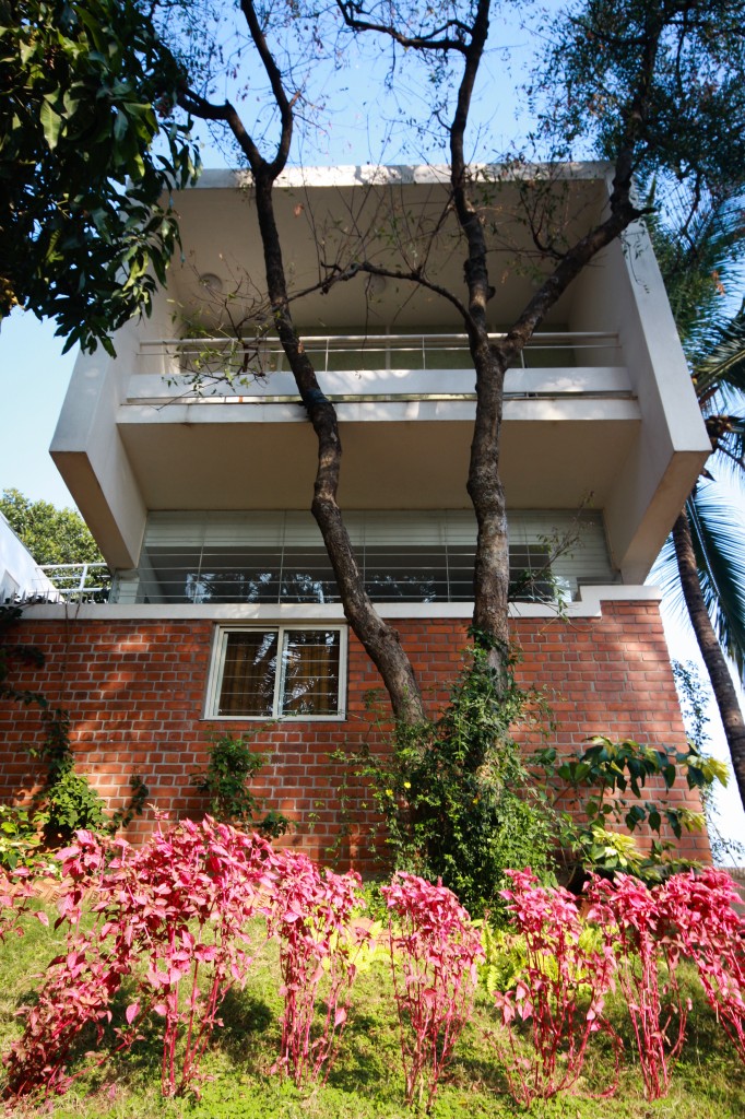 Close view of the red brick support structure rising from the garden, supporting one of the twin white structures beneath large upper balcony. Close view of the red brick support structure rising from the garden, supporting one of the twin white structures beneath large upper balcony.