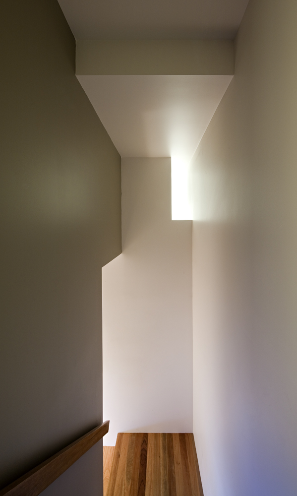 Main staircase continues expanse of white and natural wood contrast, with clever pockets of light filtering through. Main staircase continues expanse of white and natural wood contrast, with clever pockets of light filtering through.