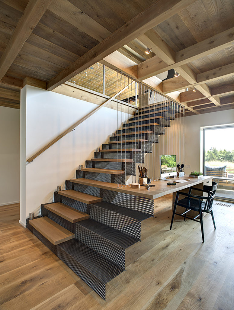 This lower level office space features unique natural wood desktop extending from stair structure, suspended via cables attached to central exposed beam. This lower level office space features unique natural wood desktop extending from stair structure, suspended via cables attached to central exposed beam.