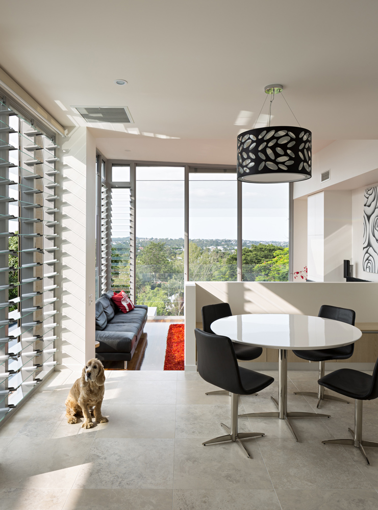 the living room space stands on rich hardwood flooring at a half lower level from the