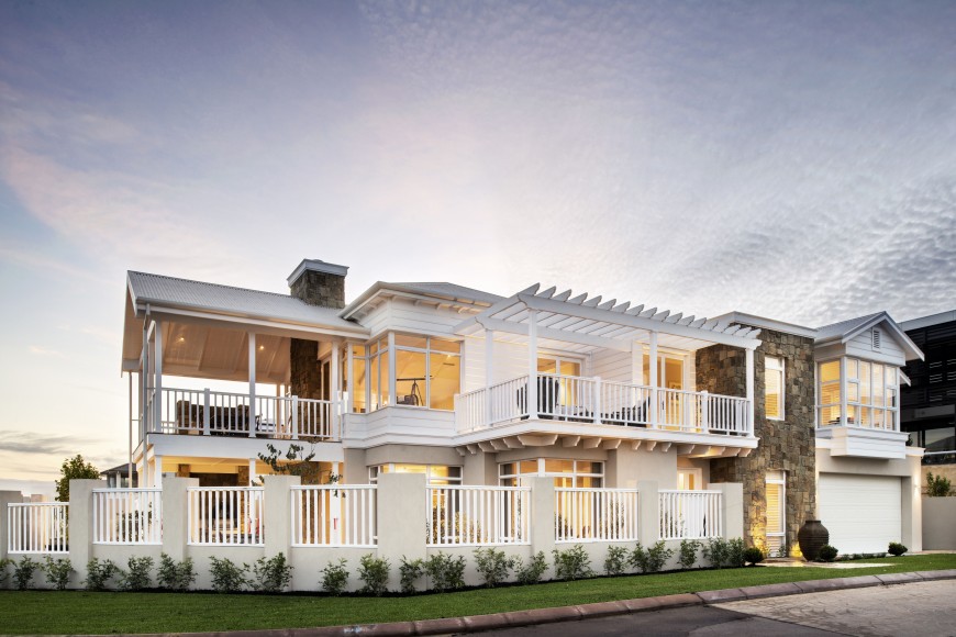 An exterior shot of the home, showing the various balconies and windows that give the home an open feel. The yard is fenced in, and the entryway is framed by natural stone masonry. An exterior shot of the home, showing the various balconies and windows that give the home an open feel. The yard is fenced in, and the entryway is framed by natural stone masonry.