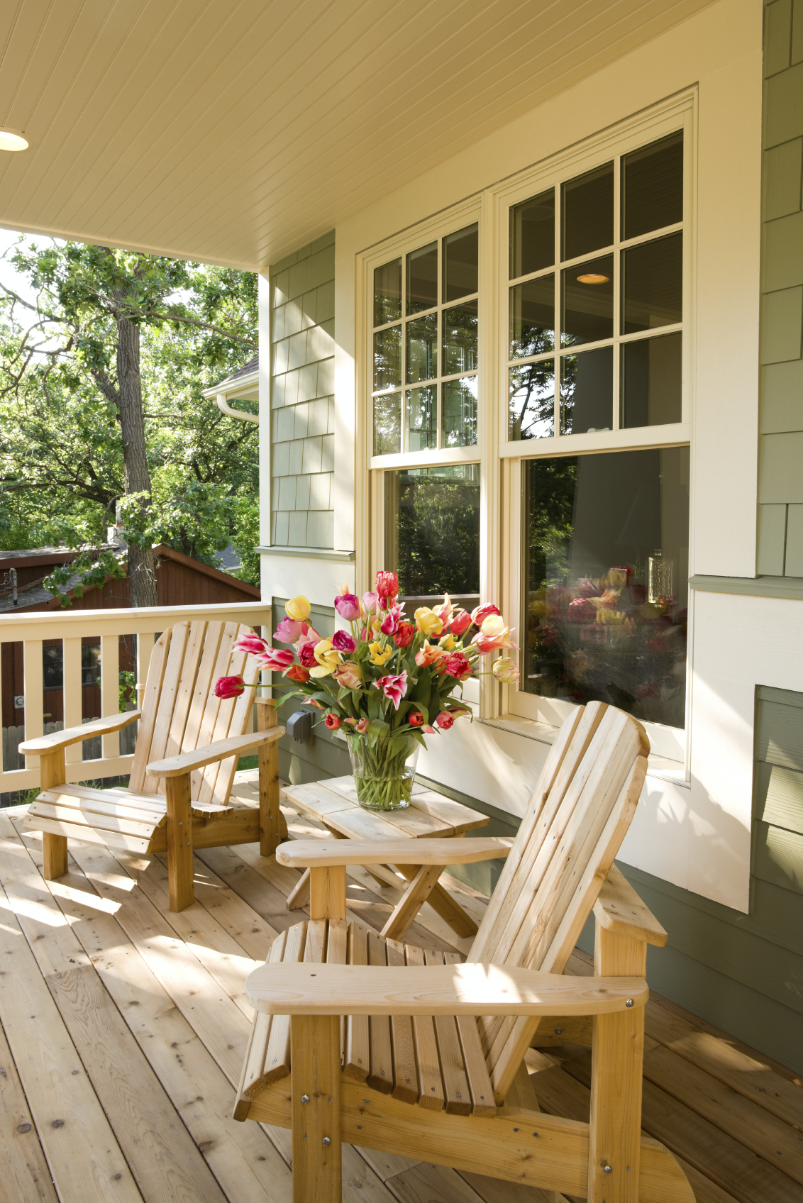 simple pine front porch with a pair of wooden lounge chairs. The 