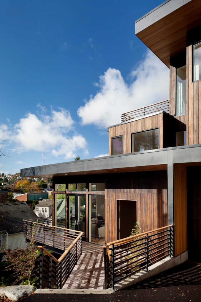 From the mid-level, we see the cedar exterior framed in black, blending into the environment. An abundance of windows throughout allows natural light to further blend the home with its surroundings. From the mid-level, we see the cedar exterior framed in black, blending into the environment. An abundance of windows throughout allows natural light to further blend the home with its surroundings.