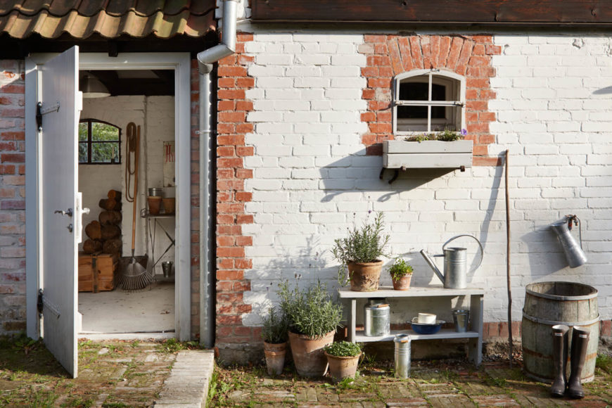 At the rear of the home, we see this brick structure, dotted with pottery and gardening supplies. At the rear of the home, we see this brick structure, dotted with pottery and gardening supplies.