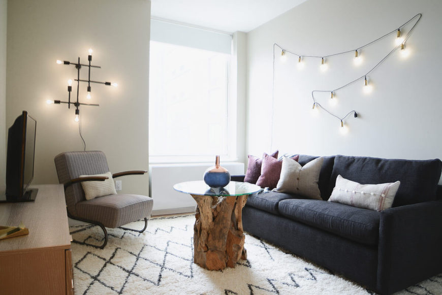 The media room, converted from a former bedroom, centers on an intriguing coffee table crafted of glass and knotty found wood. The sofa converts into a bed for when guests or children arrive. The media room, converted from a former bedroom, centers on an intriguing coffee table crafted of glass and knotty found wood. The sofa converts into a bed for when guests or children arrive.