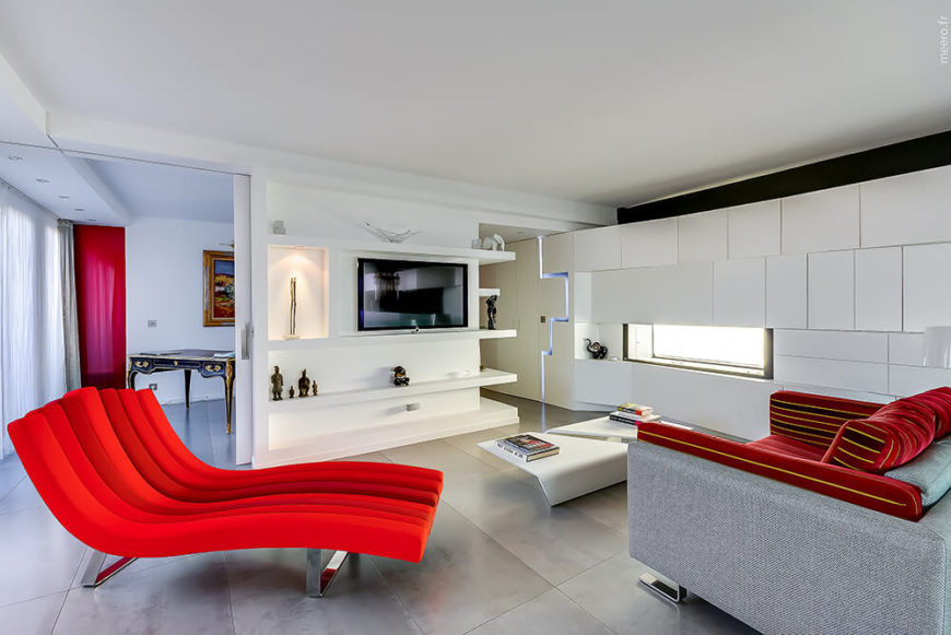 The living room is the best example for fierce and loud hues of red. This modern room is draped in mostly white, with seamless cabinets and shelves– but it has a surprise burst of red in the furniture. The living room is the best example for fierce and loud hues of red. This modern room is draped in mostly white, with seamless cabinets and shelves– but it has a surprise burst of red in the furniture.