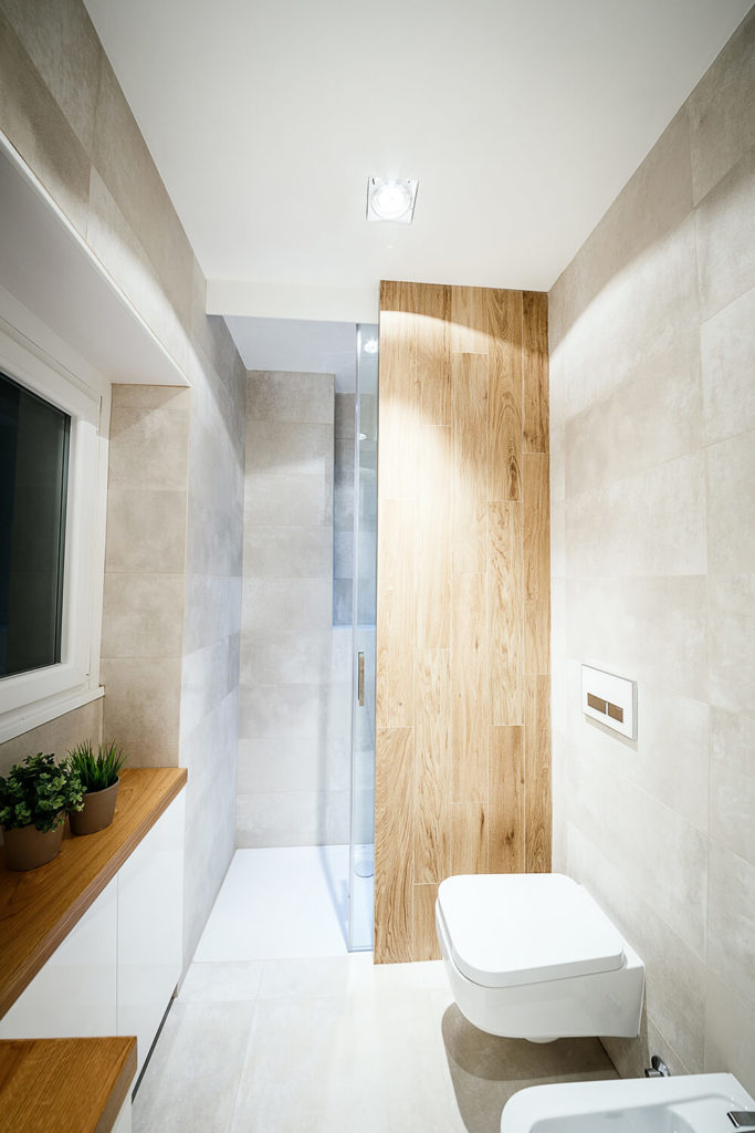The large glass enclosed, walk-in shower is partially obscured by a rich oak panel, helping divide this larger bathroom into segments. The large glass enclosed, walk-in shower is partially obscured by a rich oak panel, helping divide this larger bathroom into segments.