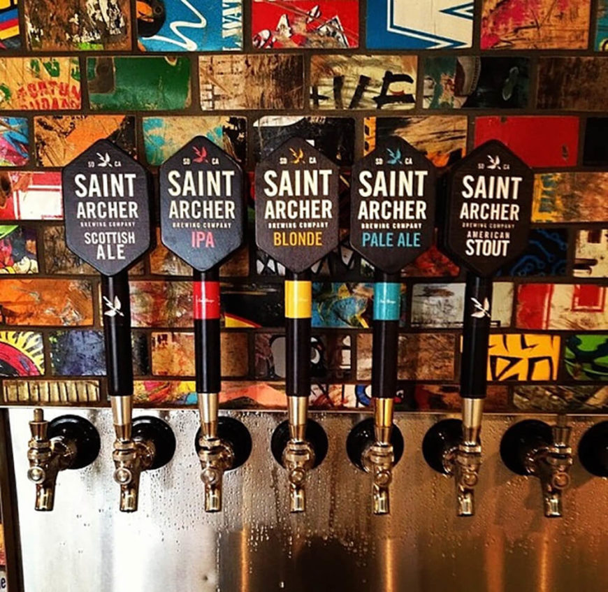 The Board & Brew Restaurant in Carlsbad, CA has a backsplash behind the taps made of recycled board art. The benefit of the board art is that even with the tap area being a messy space, the colorful and edgy design hides any kind of splashes or blemishes that might otherwise make the walls look dirty and unkept. The Board & Brew Restaurant in Carlsbad, CA has a backsplash behind the taps made of recycled board art. The benefit of the board art is that even with the tap area being a messy space, the colorful and edgy design hides any kind of splashes or blemishes that might otherwise make the walls look dirty and unkept.