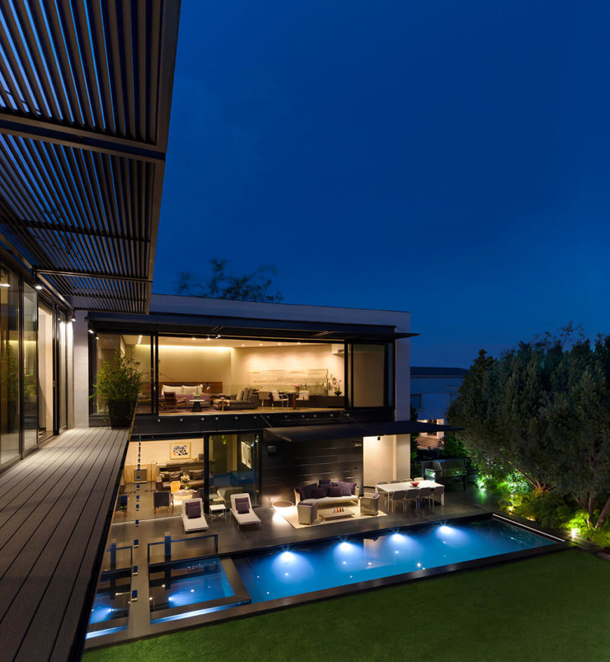 From a lengthy second floor balcony, we can see the radically open design of the home through full height windows and sliding glass panels that blur the line between interior and exterior spaces. From a lengthy second floor balcony, we can see the radically open design of the home through full height windows and sliding glass panels that blur the line between interior and exterior spaces.