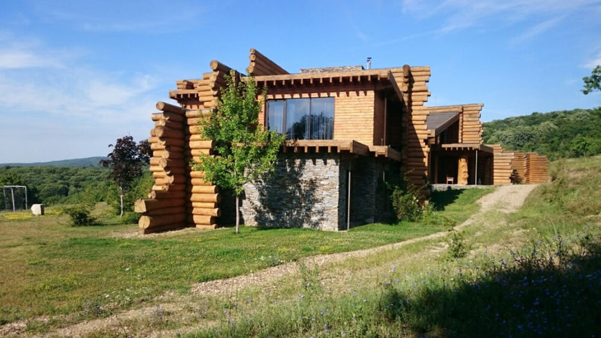 Here we see the home on approach, with the series of natural logs making for an idiosyncratic, organic shape looping from the landscape. Large expanses of glass are strategically placed to maximize sunlight usage. Here we see the home on approach, with the series of natural logs making for an idiosyncratic, organic shape looping from the landscape. Large expanses of glass are strategically placed to maximize sunlight usage.