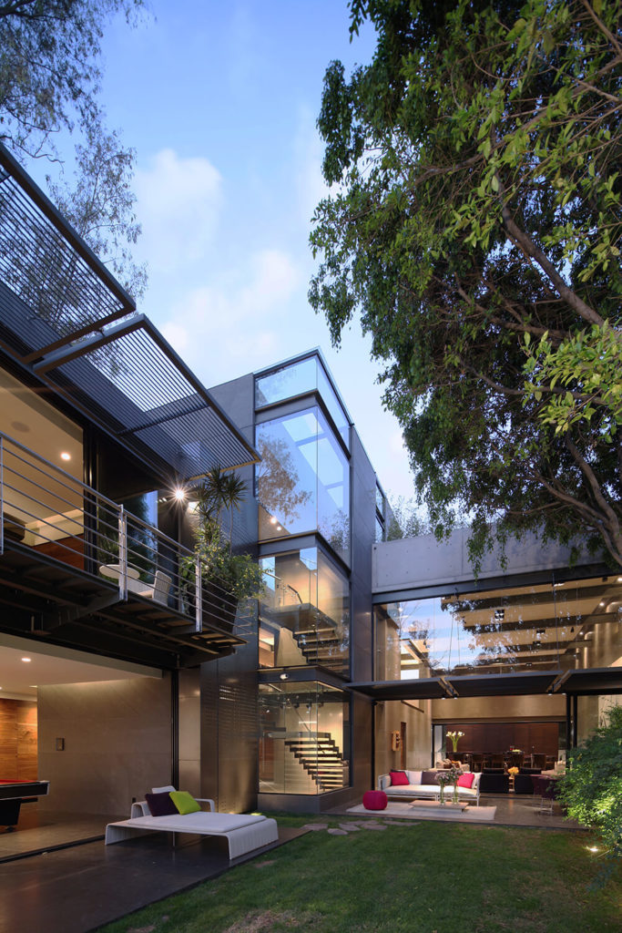 Here we can see how the lengthy volume pivots on a taller section housing the staircase, at center. Massive glass panels comprise the exterior on the southern side of the home, offering up expansive views from virtually anywhere inside. Here we can see how the lengthy volume pivots on a taller section housing the staircase, at center. Massive glass panels comprise the exterior on the southern side of the home, offering up expansive views from virtually anywhere inside.