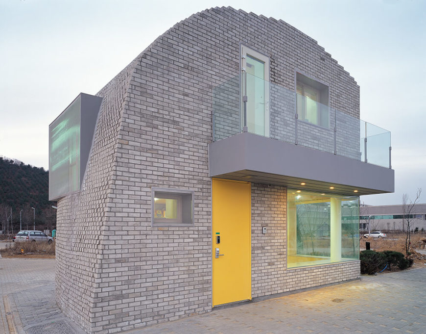 Here's a close look at the visually striking home, its organic curves turned staccato at the edges where we see individual bricks exposed. The large windows and bold yellow door make for a complex appearance. Here's a close look at the visually striking home, its organic curves turned staccato at the edges where we see individual bricks exposed. The large windows and bold yellow door make for a complex appearance.