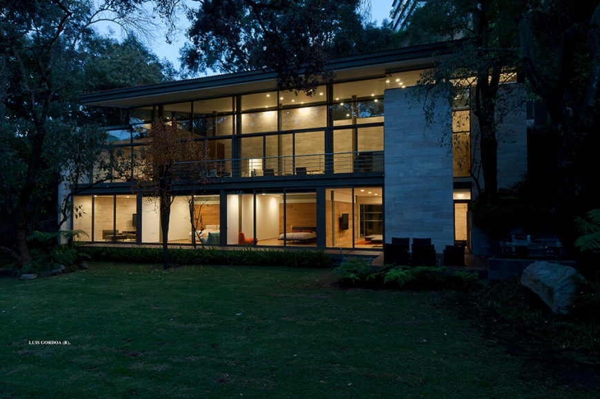 As seen from the backyard, the home is an open, glass-covered structure, welcoming and warm. The interior rooms appear detached from the outer shell. As seen from the backyard, the home is an open, glass-covered structure, welcoming and warm. The interior rooms appear detached from the outer shell.