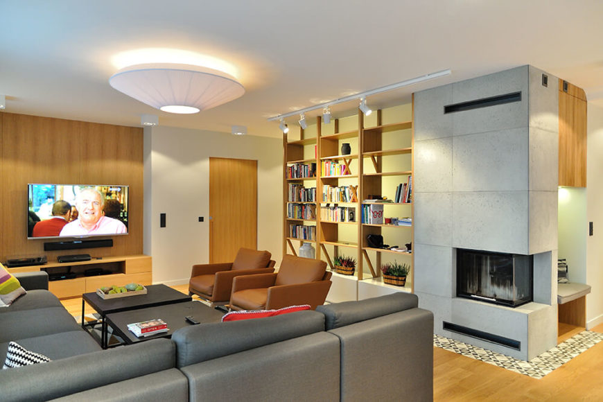 Upon entering the home, we are greeted on the left by the spacious living room area, which includes a corner fireplace shared and a small nook behind the open bookshelves. Upon entering the home, we are greeted on the left by the spacious living room area, which includes a corner fireplace shared and a small nook behind the open bookshelves.