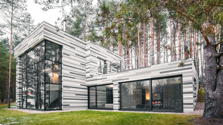 Here we see the exterior of the home that faces the river bank. The white, gray, and charcoal facade is meant to look like the characteristic striped bark of birch trees. Here we see the exterior of the home that faces the river bank. The white, gray, and charcoal facade is meant to look like the characteristic striped bark of birch trees.